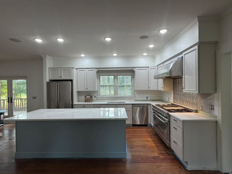 Kitchen with freshly painted light grey cabinets and a blue-grey island, photographed by AP Painting & Cleaning